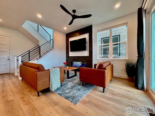 living area with light wood finished floors, stairs, recessed lighting, and a ceiling fan