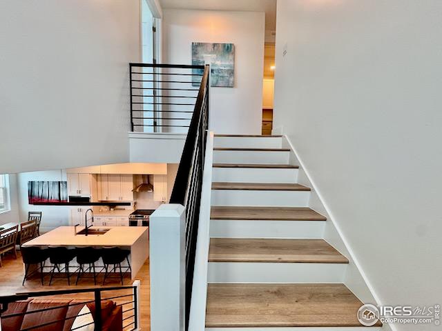 staircase with baseboards and wood finished floors