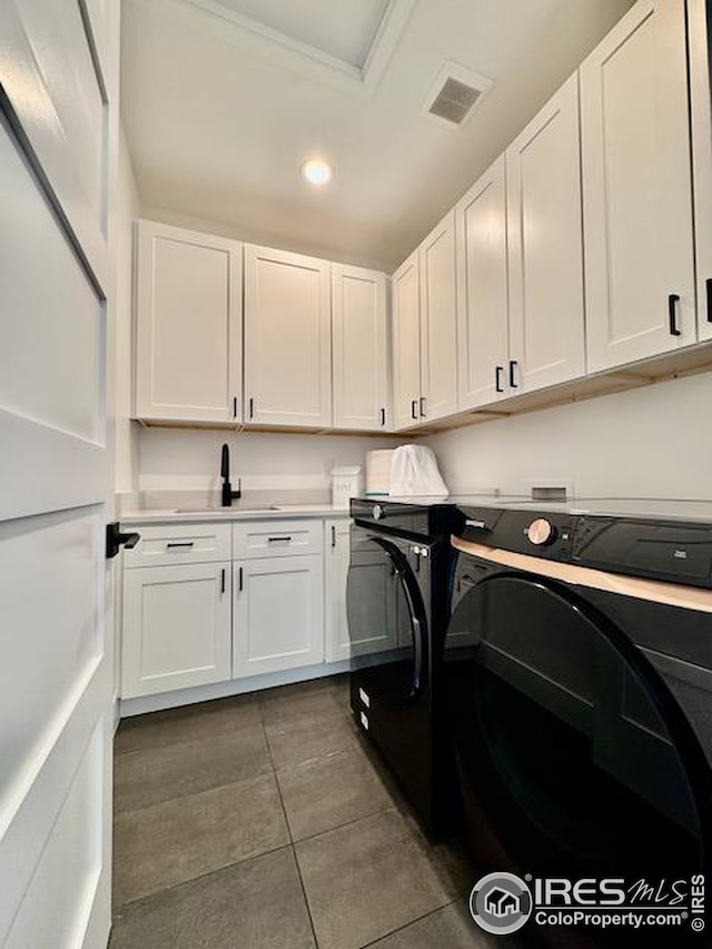 laundry area featuring recessed lighting, dark tile patterned floors, separate washer and dryer, visible vents, and cabinet space
