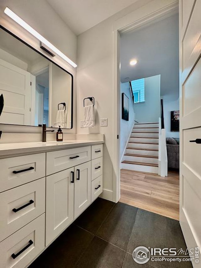 bathroom featuring vanity, baseboards, and wood finished floors
