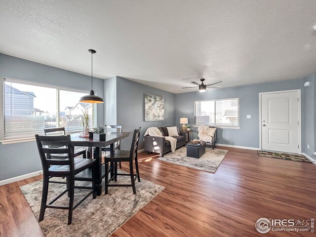 dining area featuring plenty of natural light, baseboards, wood finished floors, and ceiling fan