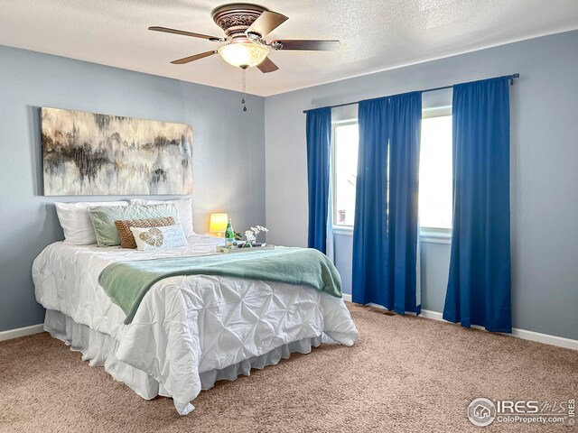 bedroom featuring baseboards, carpet flooring, a textured ceiling, and a ceiling fan
