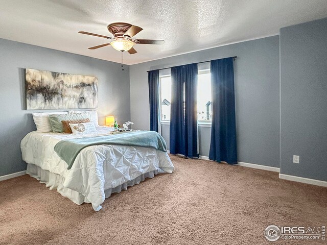 bedroom with baseboards, carpet floors, and a textured ceiling