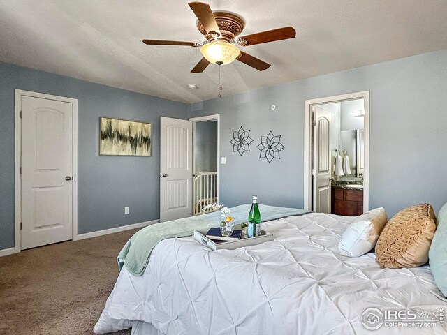 bedroom featuring baseboards, ceiling fan, carpet floors, and ensuite bath