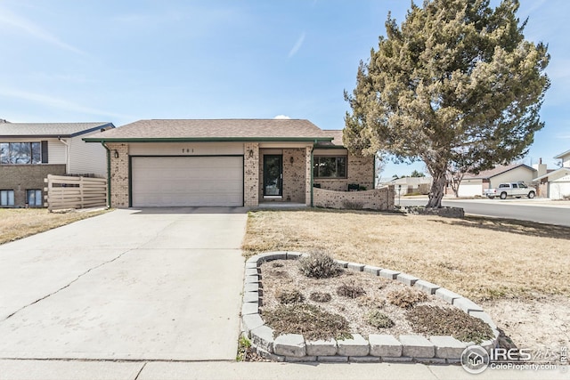 701 43rd Ave, Greeley, CO 80634 - view of front of home featuring a garage, brick siding, and concrete driveway