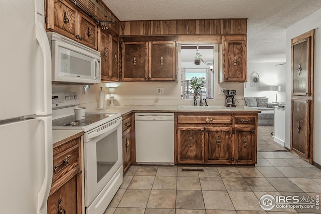 701 43rd Ave, Greeley, CO 80634 - kitchen with light countertops, a sink, a textured ceiling, and white appliances