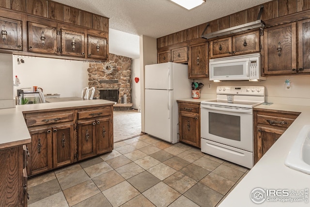 701 43rd Ave, Greeley, CO 80634 - kitchen with a textured ceiling, light countertops, a fireplace, and white appliances