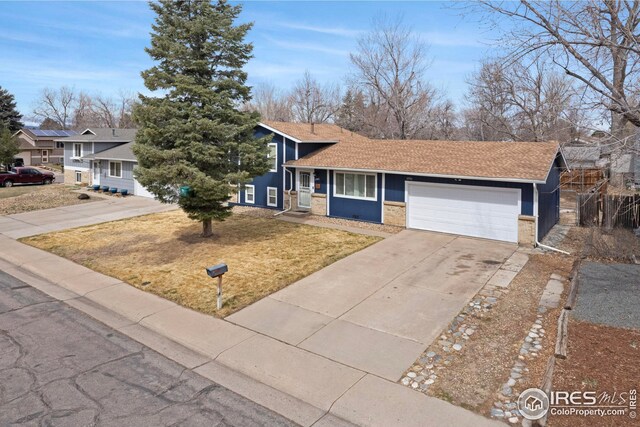 12901 E Idaho Dr, Aurora, CO 80012 - view of front of property with driveway, an attached garage, brick siding, and roof with shingles