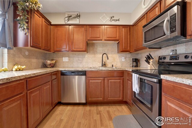 12901 E Idaho Dr, Aurora, CO 80012 - kitchen with a sink, backsplash, light wood-style floors, and appliances with stainless steel finishes