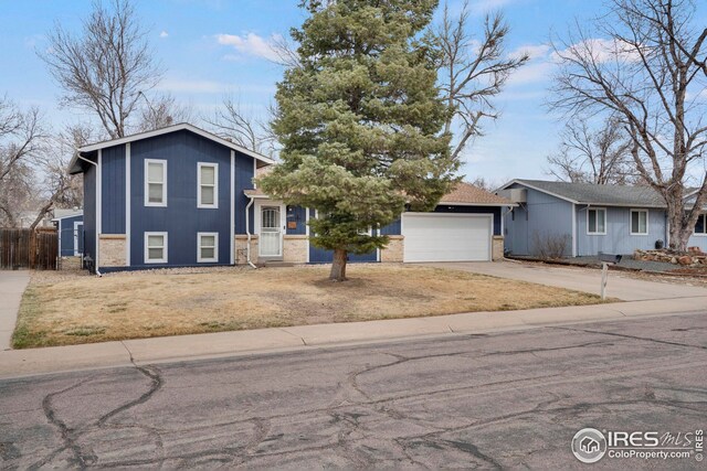 12901 E Idaho Dr, Aurora, CO 80012 - split level home featuring fence, driveway, a garage, and brick siding