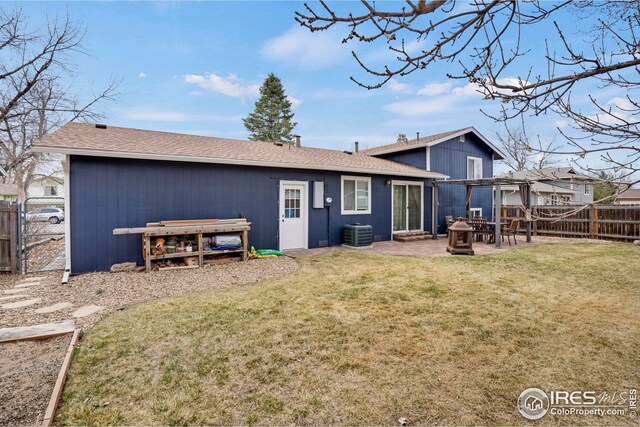12901 E Idaho Dr, Aurora, CO 80012 - back of property with a gate, a fenced backyard, a patio, a lawn, and central AC