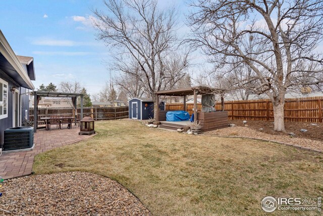 12901 E Idaho Dr, Aurora, CO 80012 - view of yard featuring central AC, a fenced backyard, a storage unit, an outdoor structure, and a patio area