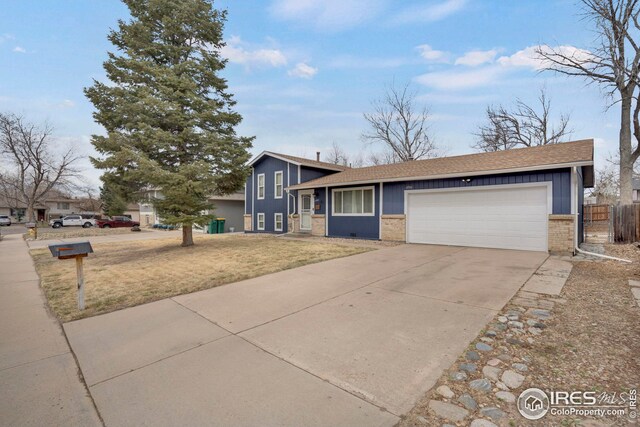 12901 E Idaho Dr, Aurora, CO 80012 - split level home featuring roof with shingles, fence, driveway, brick siding, and a garage