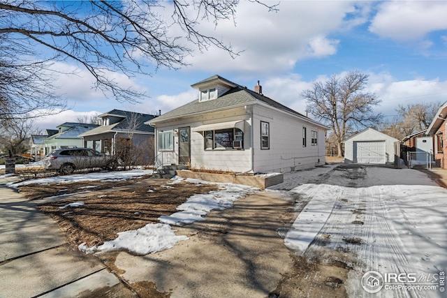 919 State St, Fort Morgan, CO 80701 - snow covered property with a garage, an outdoor structure, driveway, a chimney, and entry steps
