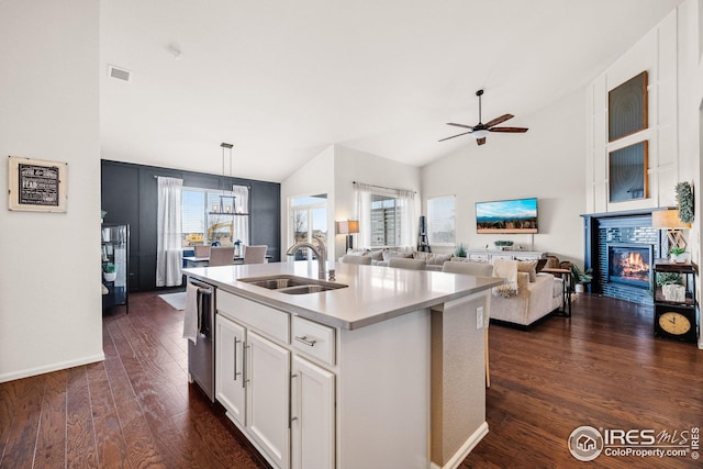 kitchen with plenty of natural light, dark wood-style floors, a tile fireplace, and a sink