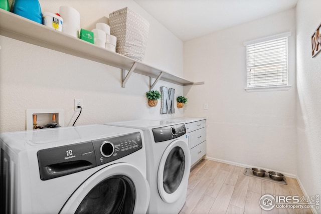 laundry area with washing machine and clothes dryer, baseboards, light wood finished floors, and laundry area