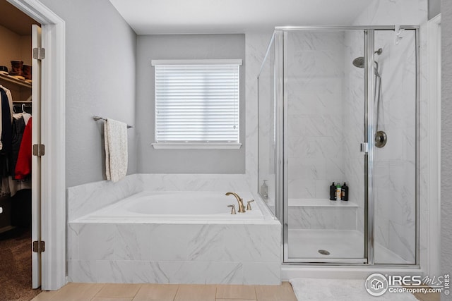 full bathroom with a bath, a marble finish shower, and a walk in closet