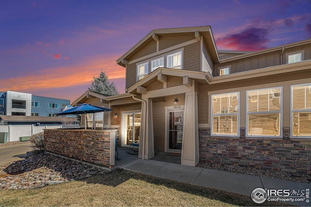 rear view of property with stone siding, outdoor dry bar, area for grilling, and a patio area