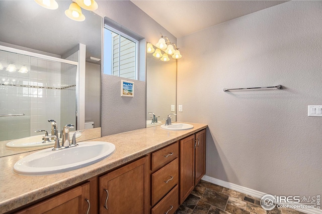 full bathroom featuring a sink, stone finish flooring, a stall shower, and baseboards