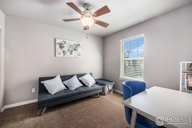 carpeted office space featuring baseboards and ceiling fan
