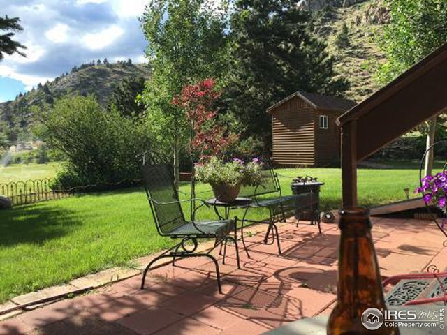 view of patio / terrace featuring an outbuilding, a mountain view, and fence