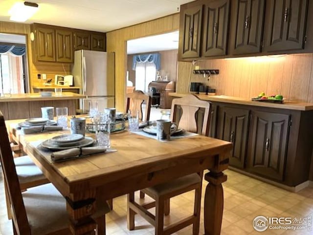 dining space with wood walls and light floors