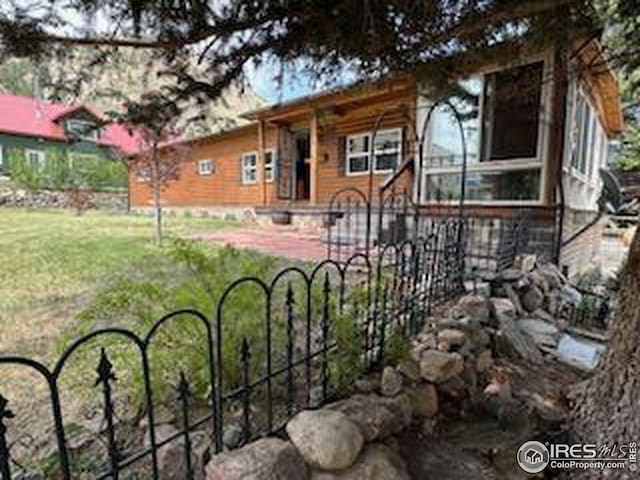 view of front facade featuring a front yard and fence
