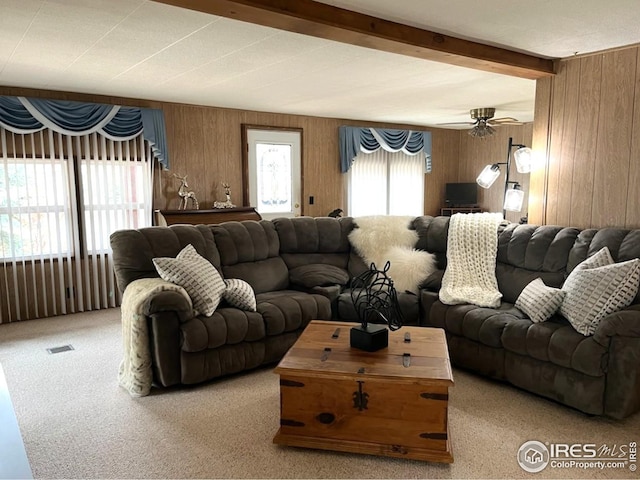 carpeted living area with a ceiling fan, visible vents, and beamed ceiling