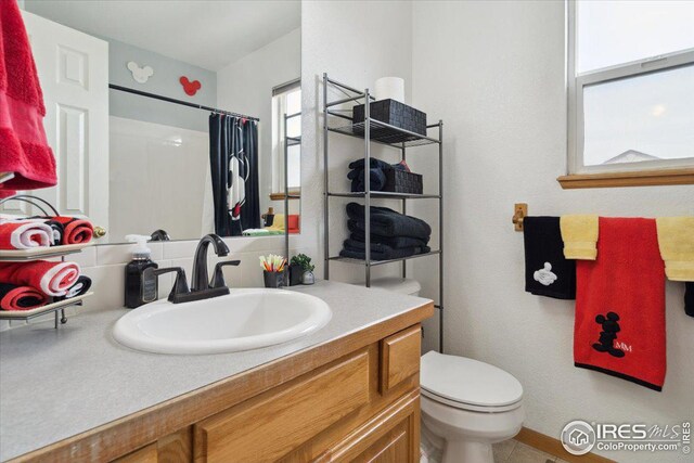 1725 67th Ave, Greeley, CO 80634 - full bath featuring toilet, vanity, and a shower with curtain