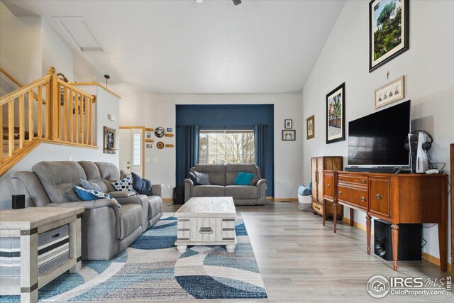 1725 67th Ave, Greeley, CO 80634 - living room with stairs, attic access, wood finished floors, lofted ceiling, and baseboards