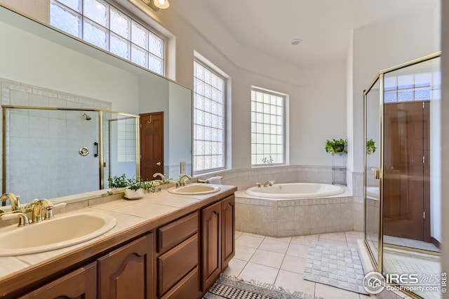 bathroom with tile patterned floors, a sink, a stall shower, and a garden tub