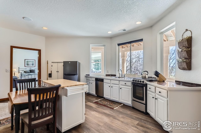 kitchen with recessed lighting, dark wood-type flooring, visible vents, white cabinets, and appliances with stainless steel finishes