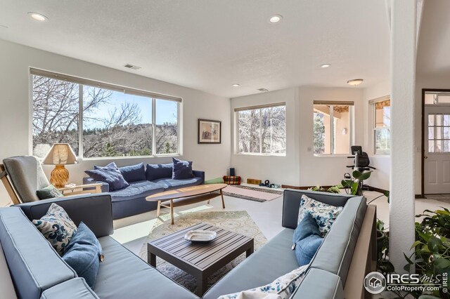 living area featuring visible vents and recessed lighting