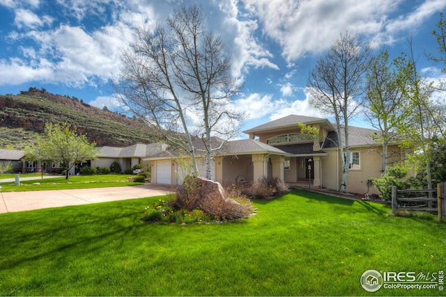 view of front of house featuring stucco siding, an attached garage, a front lawn, and concrete driveway