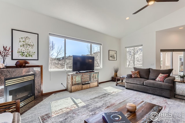 living room featuring carpet floors, lofted ceiling, a high end fireplace, baseboards, and ceiling fan