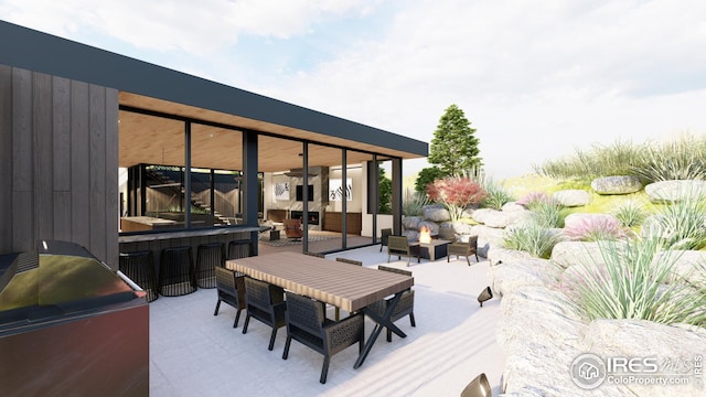 wooden deck featuring an outdoor fire pit, outdoor dining space, and a patio area