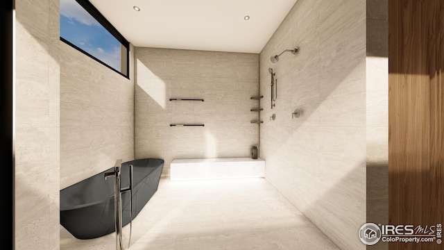 interior space featuring tile walls, a freestanding tub, and a shower