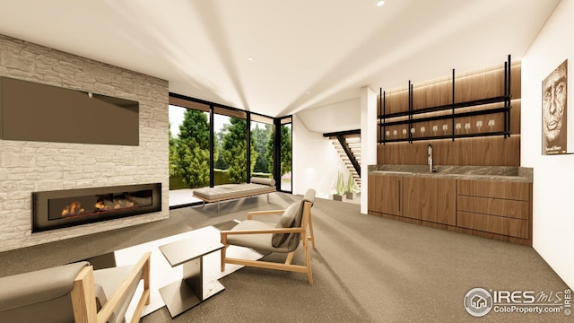 carpeted living room with indoor wet bar, expansive windows, and a fireplace