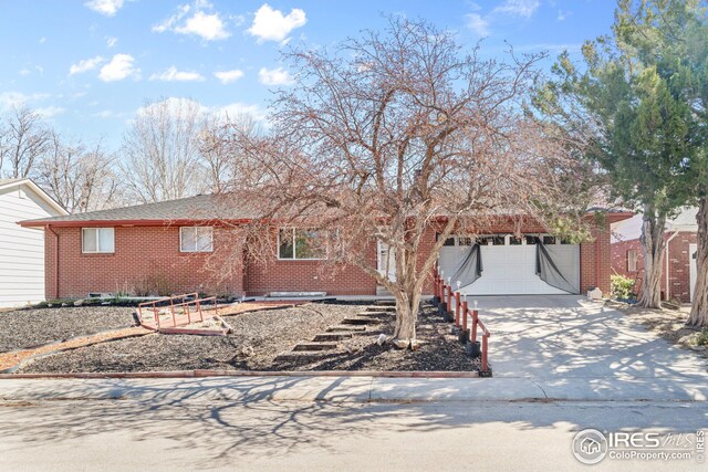 ranch-style house with brick siding, an attached garage, and concrete driveway