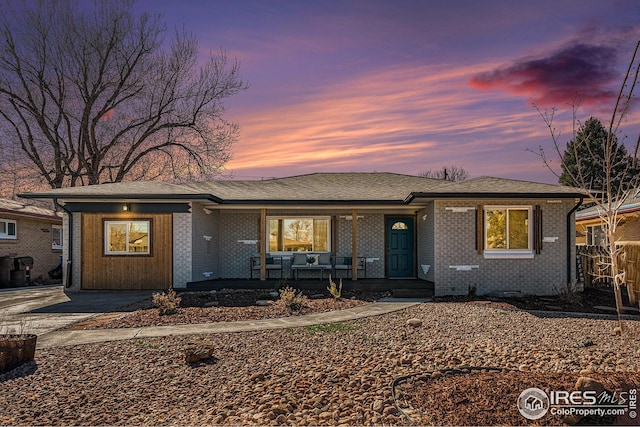 191 Emerald St, Broomfield, CO 80020 - view of front of house featuring a shingled roof, covered porch, and brick siding