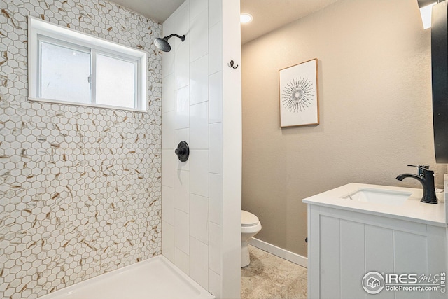 191 Emerald St, Broomfield, CO 80020 - bathroom featuring baseboards, a tile shower, toilet, and a sink
