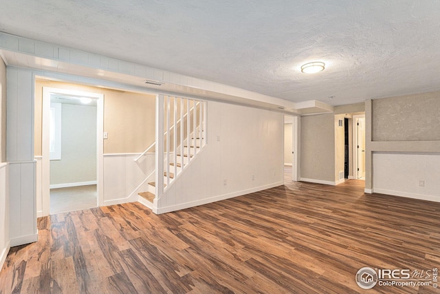 191 Emerald St, Broomfield, CO 80020 - finished below grade area featuring stairway, baseboards, a textured ceiling, visible vents, and wood finished floors
