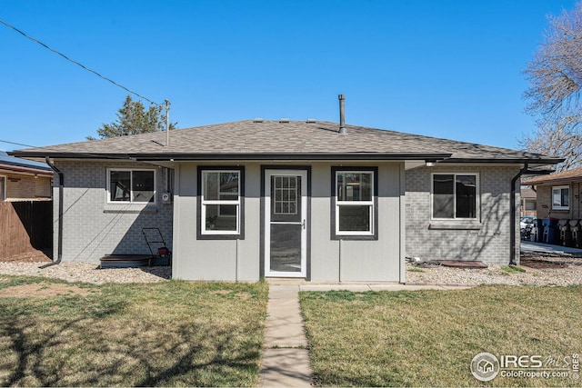 191 Emerald St, Broomfield, CO 80020 - rear view of property featuring a lawn, fence, brick siding, and roof with shingles