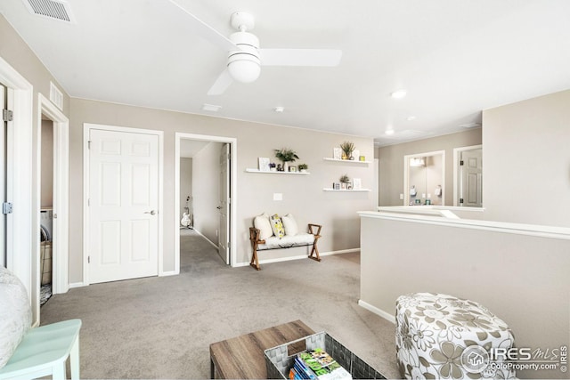 living room with baseboards, carpet flooring, visible vents, and a ceiling fan