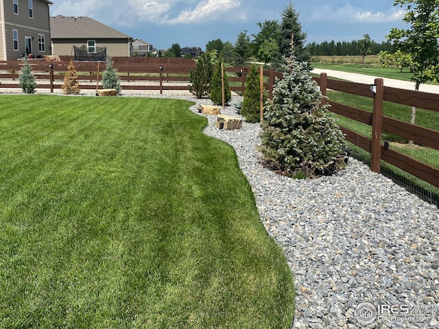 view of yard featuring fence and a rural view