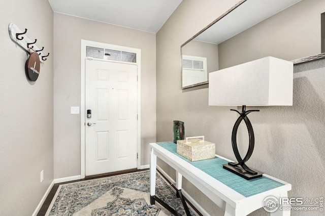 entryway featuring baseboards and wood finished floors