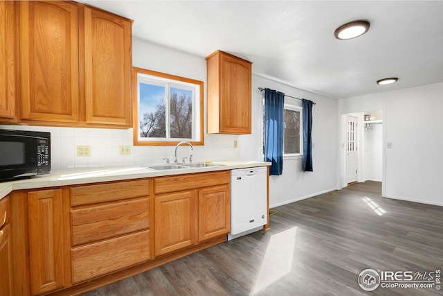 kitchen with white dishwasher, black microwave, a sink, and backsplash
