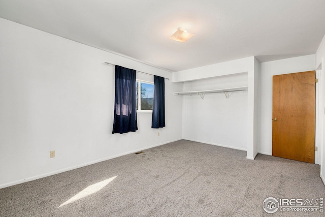 unfurnished bedroom with carpet flooring and baseboards