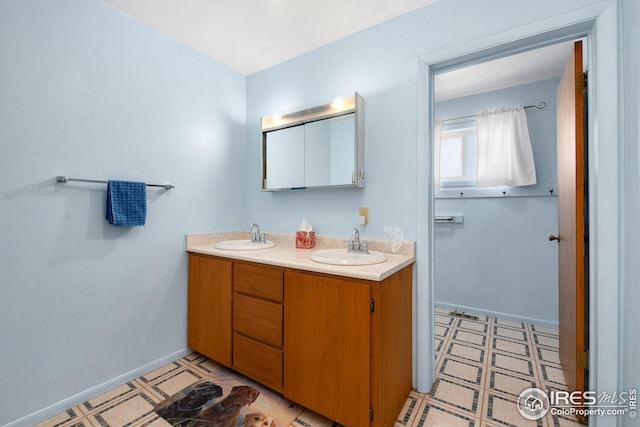 bathroom featuring tile patterned floors, double vanity, and baseboards