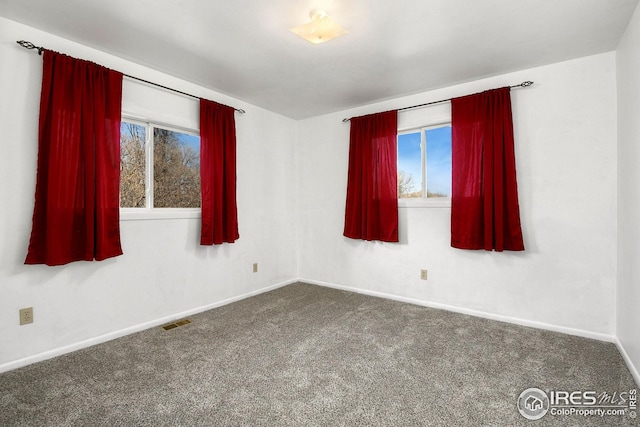 empty room featuring carpet floors and baseboards